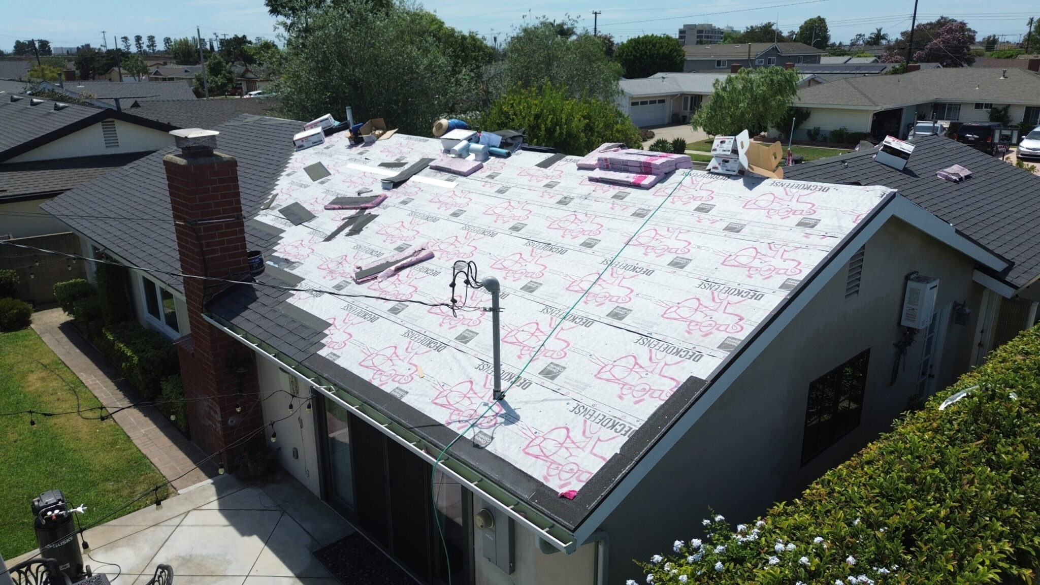 Aerial view of residential roof inspection and maintenance work in progress
